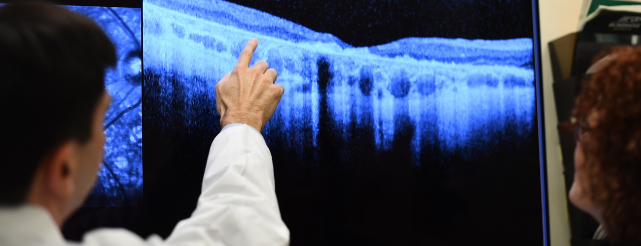 Dr. Jason Comander reviews an image on television screen with a patient