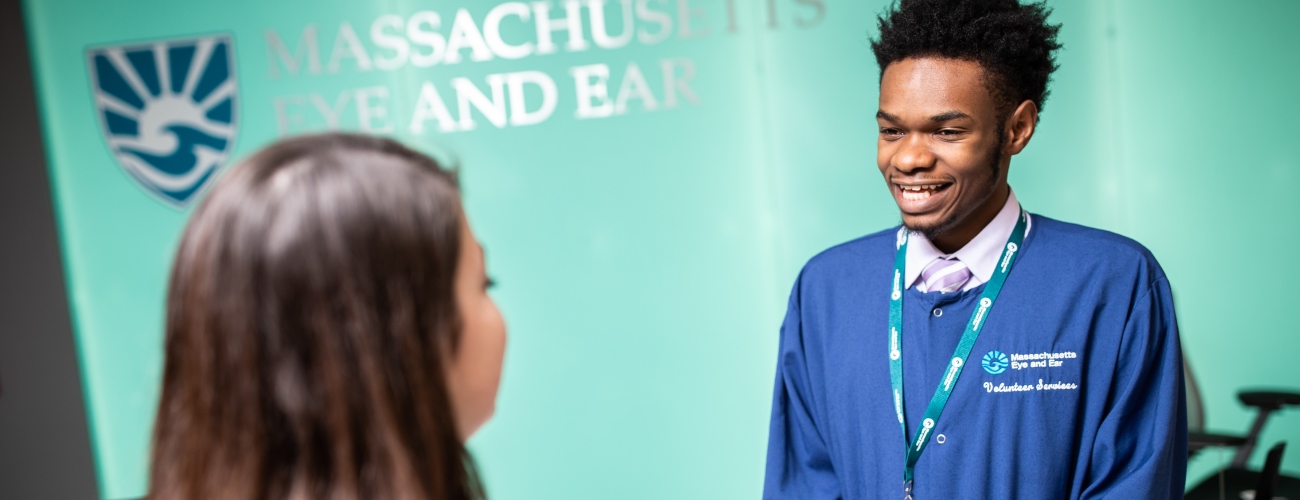 Mass Eye and Ear volunteer greets a patient in lobby