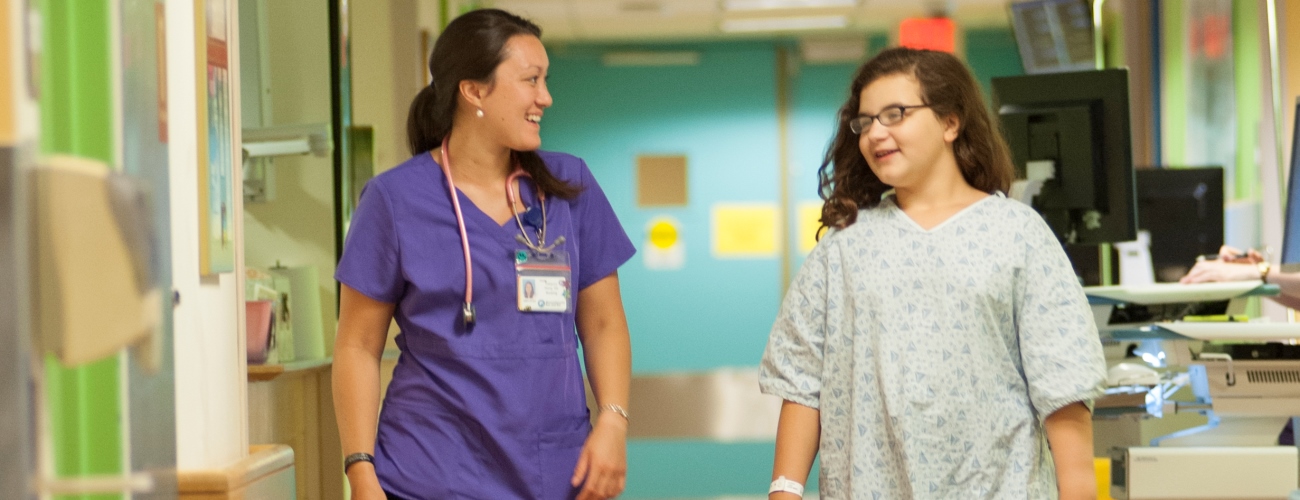 nurse and pediatric patient walking in hallway