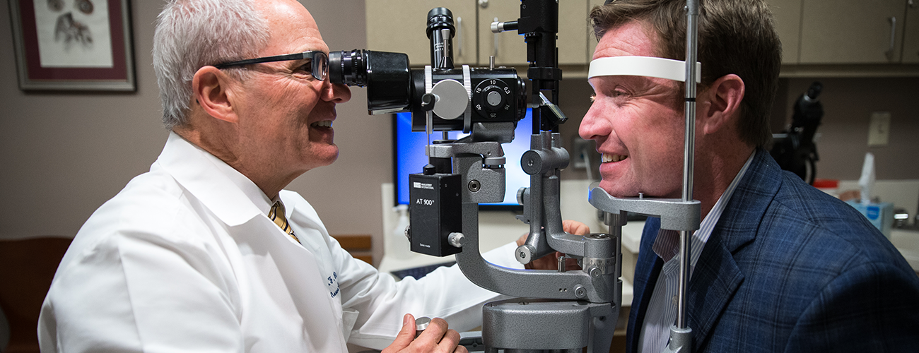 eye specialist performing a follow-up exam on a patient