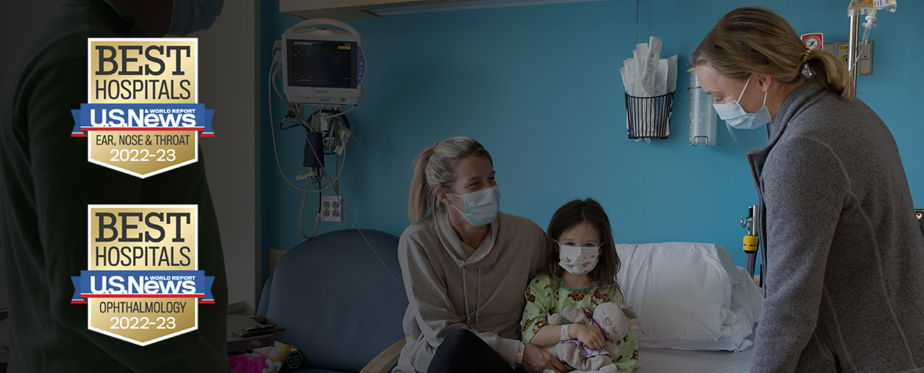 nurse with pediatric patient and her family with US News badges at left