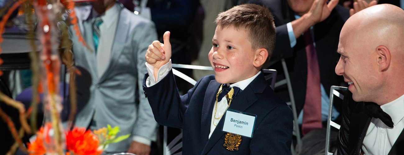 young boy with thumb up at gala