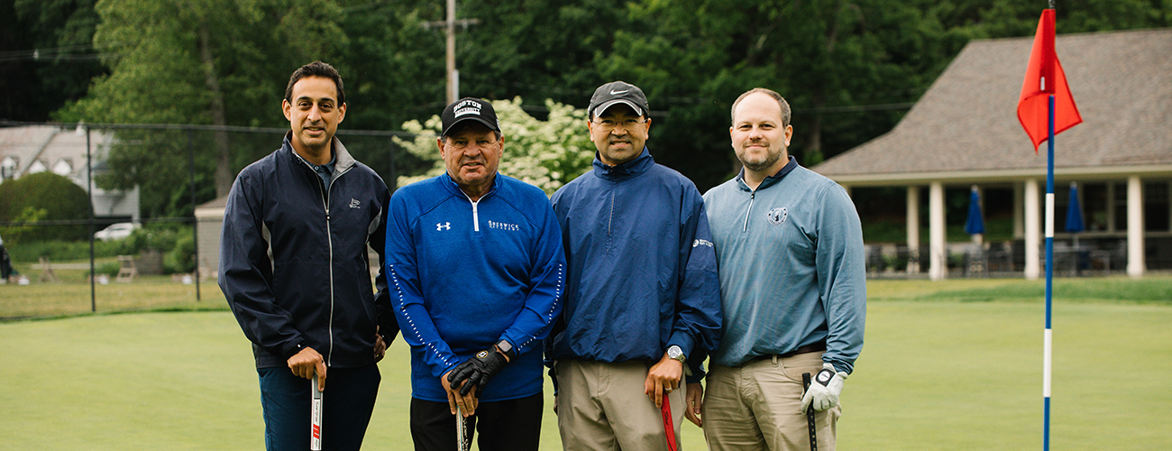 four attendees at mass eye and ear golf tournament