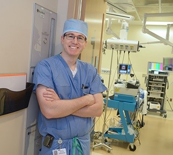 Benjamin Bleier, MD, standing against wall in operating room