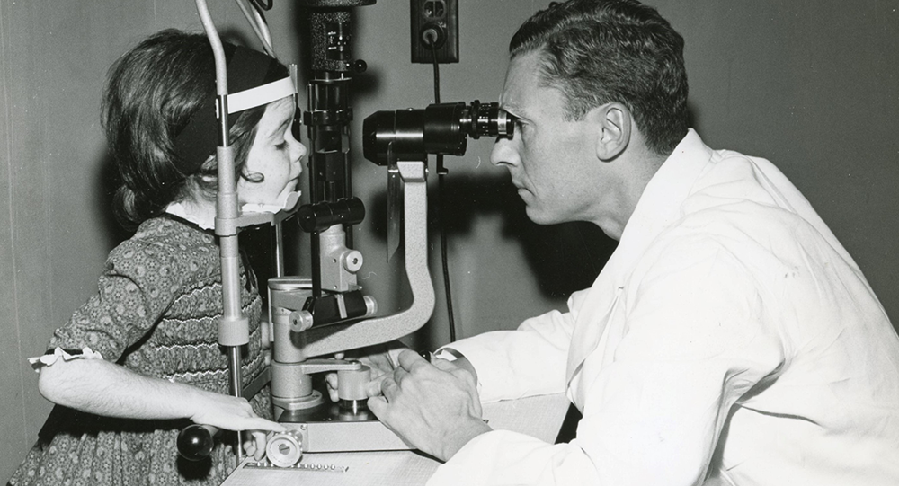 Claus Dohlman performing eye exam on pediatric patient