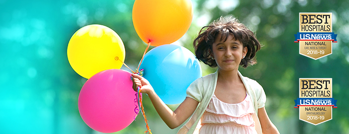 young girl holding balloons with US News and World Report badges on right